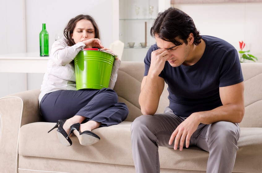 муж и жена сидят на диване с плохим самочувствием
