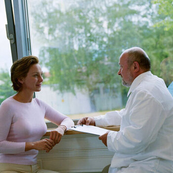 Женщина беседует с врачом у окна